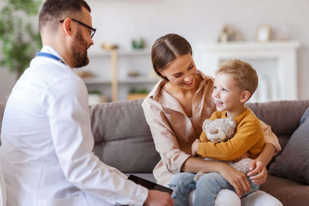 happy child boy patient with his mother at reception of a friendly pediatrician family doctor family pediatrician
