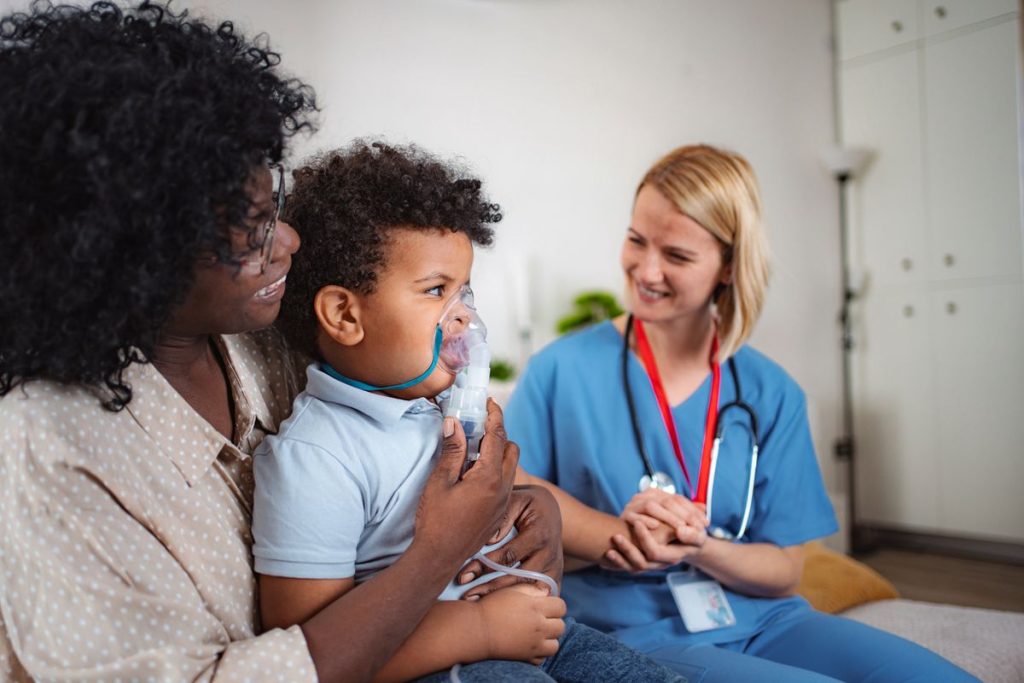 Pediatric nebulizer treatment home visit Pediatric nurse giving a young child a nebulizer treatment during a home visit